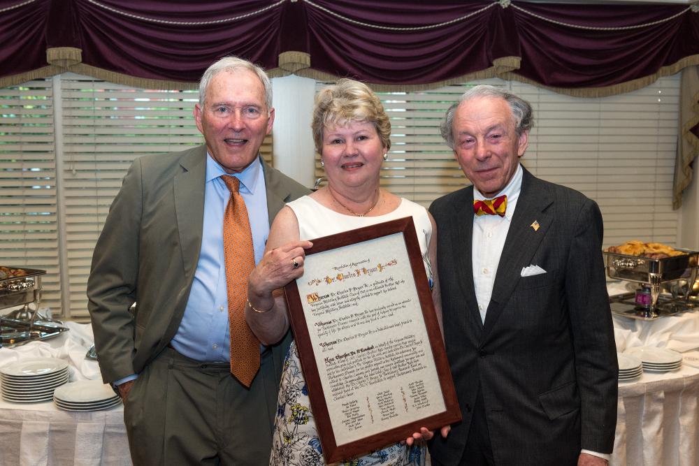 Charlie Bryan and his wife Cammy Bryan, along with John Ishon, look over a resolution in appreciation of Charlie that was presented at the reception where the Dr. Charles F. Bryan Jr. Parkinson’s Research Fund was announced.