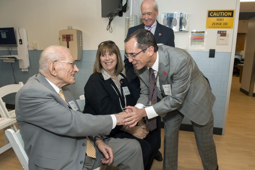 Stan Pauley (left) greets Dr. Hundley in 2018 before the ribbon cutting at the Pauley Heart Center Cardiac Imaging Clinic. Kathy Pauley Hickok and Gene Hickok are also pictured as they await the ribbon cutting.