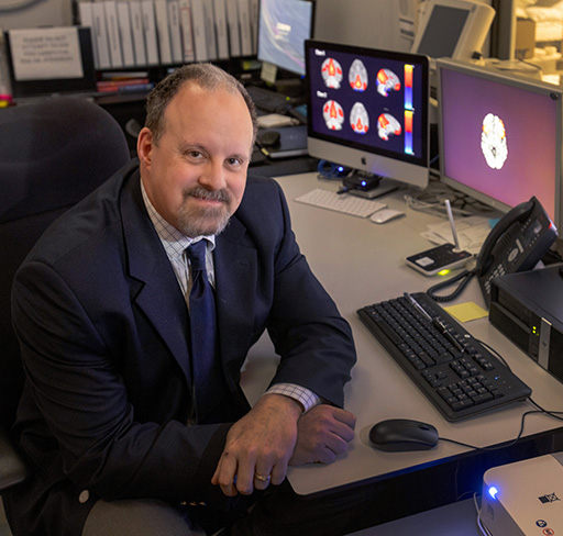 Dr. Bjork sits in brain imaging lab.