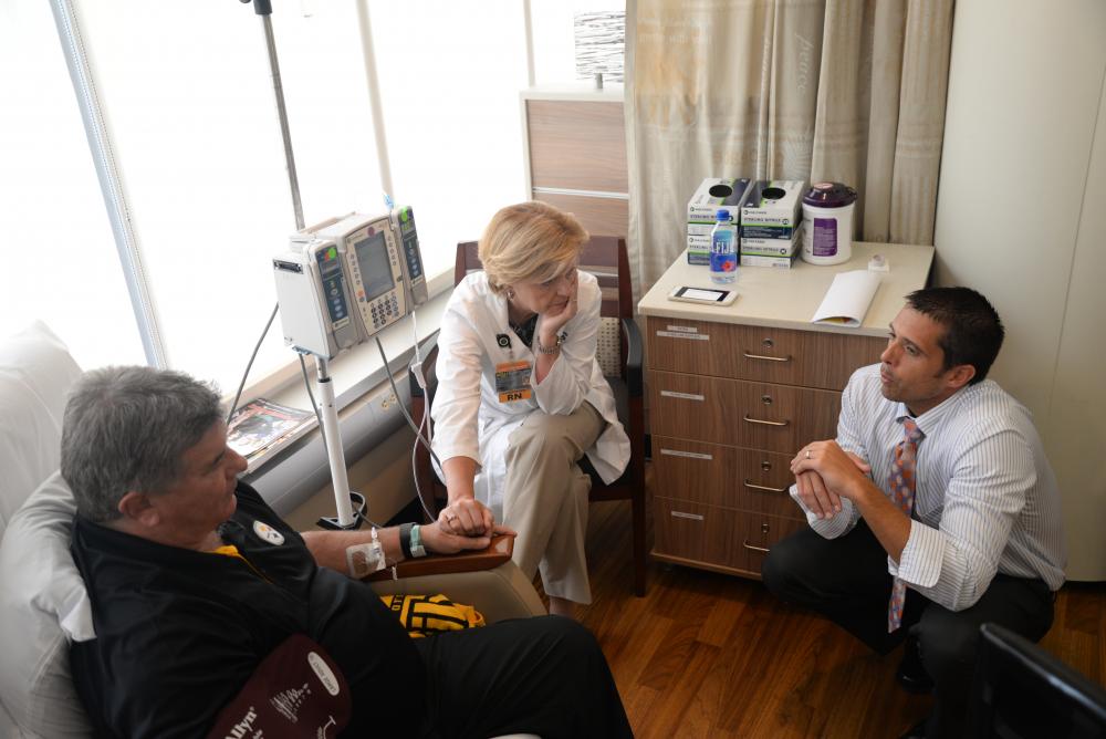 Scott Vota (right), D.O., speaks with Jerry and Sue Creehan on Aug. 23 as Jerry receives an infusion to treat ALS. Photo: VCU Public Affairs