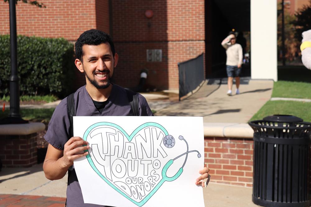Student holding sign saying thank you donors