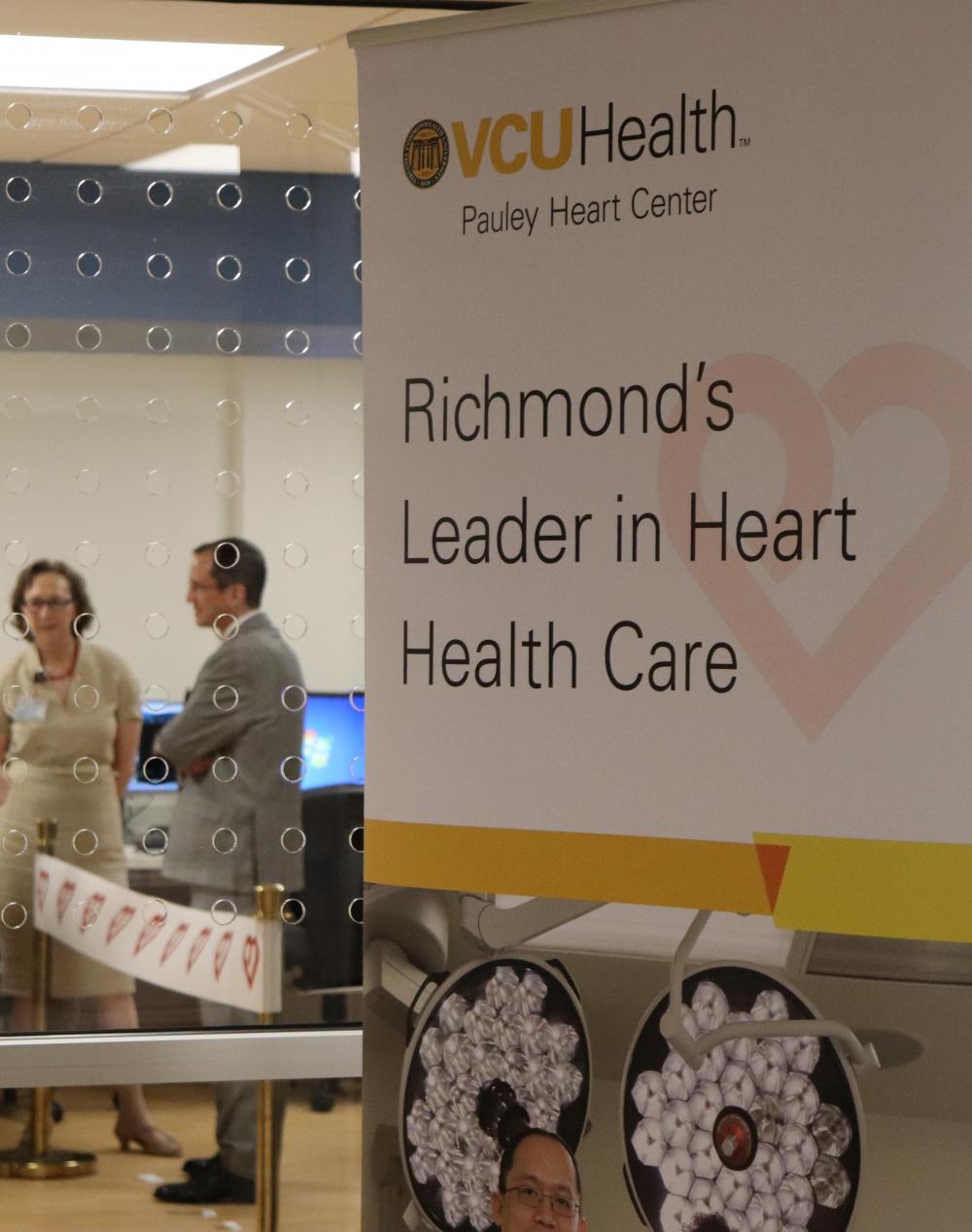 In the background, Marsha Rappley, M.D., vice president for health sciences and CEO of the VCU Health System, and William Hundley, M.D., director of the Pauley Heart Center, prepare for the ribbon cutting at VCU Health’s new Cardiac Imaging Suite.