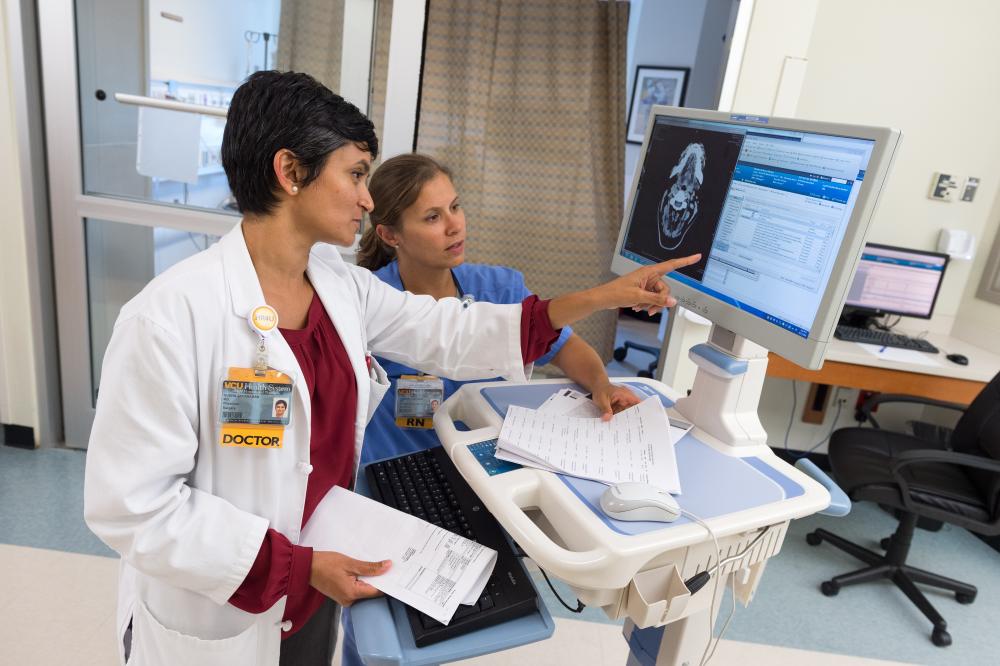 Dr. Jayaraman and Kimberly Baldwin, R.N., read through a medication list and discuss a patient’s case in the surgical/trauma ICU at VCU Medical Center. Photo: Kevin Schindler