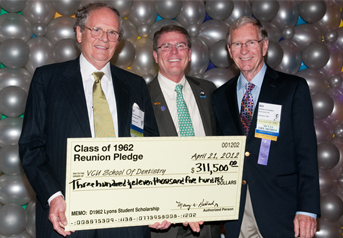 Men posing with a giant check