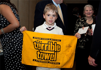 Event attendee Will Tunner show one of the evening’s auction items: a signed terrible towel from the Steelers