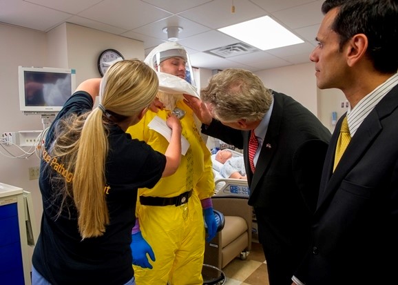Former Virginia Gov. Terry McAuliffe (center) and VCU President Michael Rao, Ph.D., examine equipment in 2015 demonstrated by a VCU Medical Center’s Unique Pathogens Unit team member. Photo: Courtesy of VCU University Marketing.