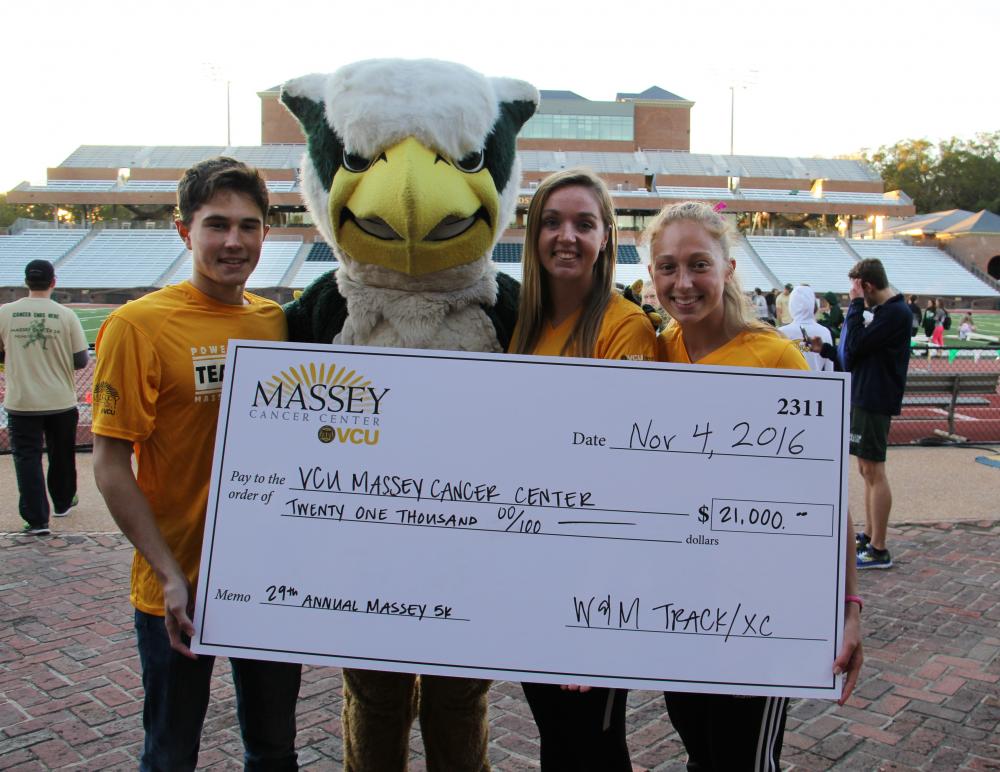 Members of the W&M track team hold a check from the 2016 Massey Cancer Center 5K.