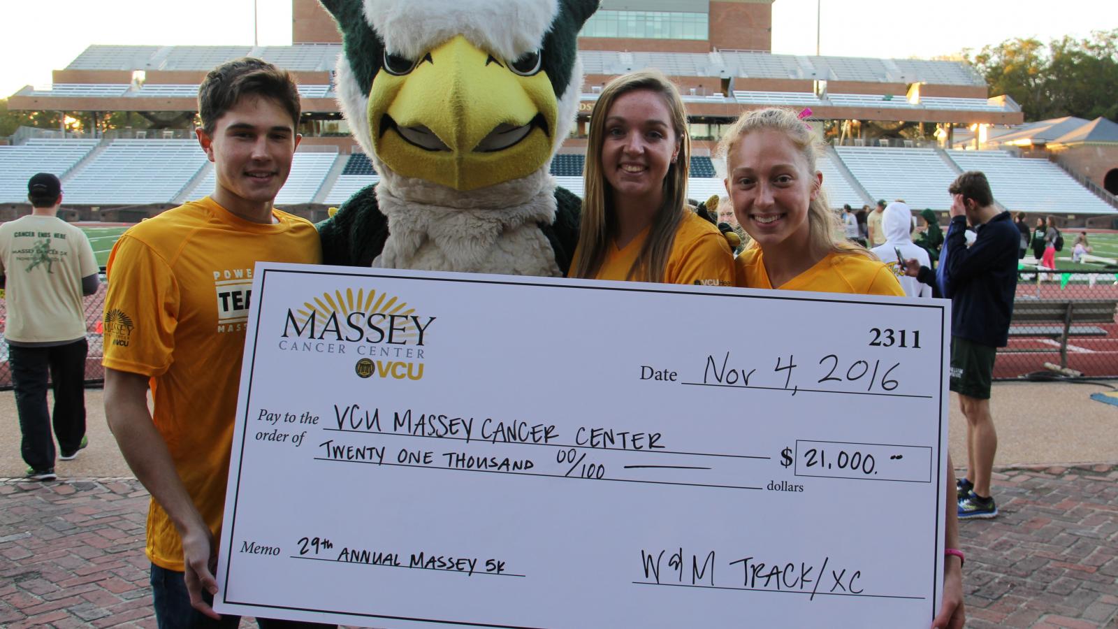Members of the W&M track team hold a check from the 2016 Massey Cancer Center 5K.