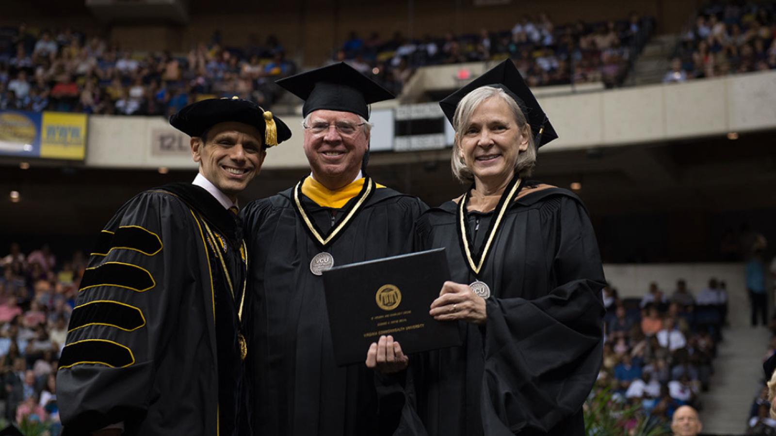 Charles and Ginny Crone (center and right) stand with Michael Rao, Ph.D., president of VCU and VCU Health System, after receiving the Edward A. Wayne Medal at VCU's commencement on May 12.