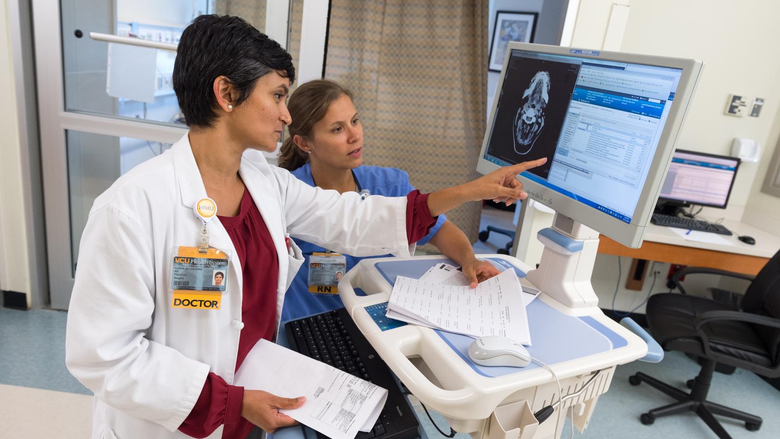 Dr. Jayaraman and Kimberly Baldwin, R.N., read through a medication list and discuss a patient’s case in the surgical/trauma ICU at VCU Medical Center. Photo: Kevin Schindler