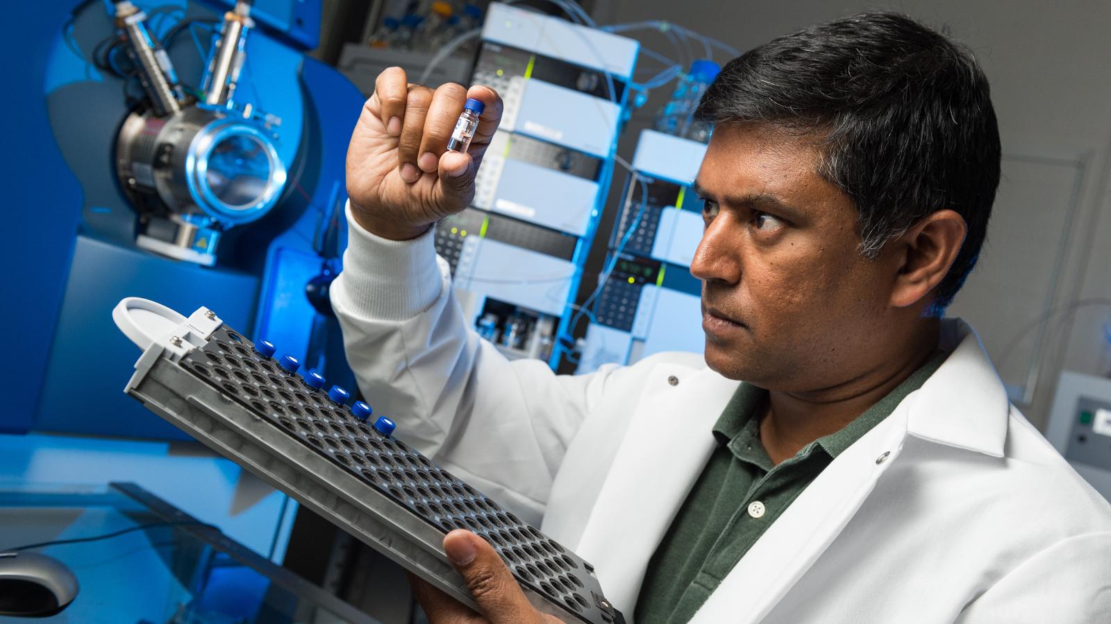 Dr. Wijesinghe examines a patient’s plasma sample extract before analyzing it with the chromatographic separation device and mass spectrometer on the MCV Campus at VCU Health. Photo: Kevin Schindler