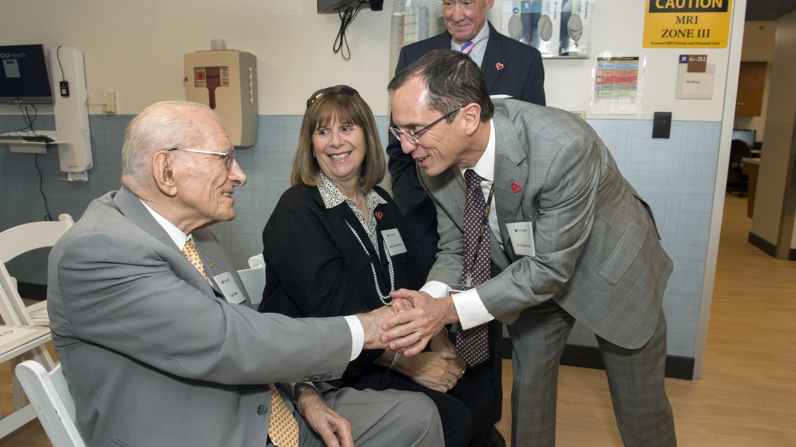Stan Pauley (left) greets Dr. Hundley in 2018 before the ribbon cutting at the Pauley Heart Center Cardiac Imaging Clinic. Kathy Pauley Hickok and Gene Hickok are also pictured as they await the ribbon cutting.