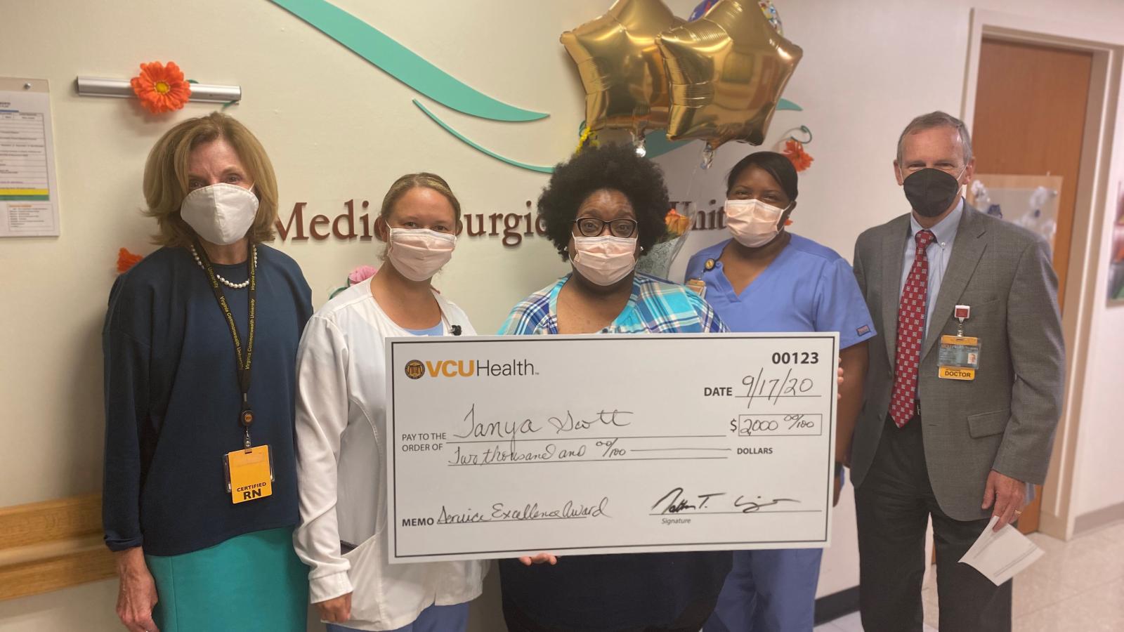 (L to R) Deborah Zimmermann, D.N.P, former chief nursing officer and vice president of patient care services; Nina Carter, nurse manager; Tanya Scott, nurse clinician and 2020 Service Excellence Award recipient; Tashika Nixon, nurse clinician; and Ron Clark, M.D., interim Chief Executive Officer, VCU Hospitals and Clinics, gather to celebrate Tanya’s achievements and contributions to VCU Health. Photo courtesy of VCU Health